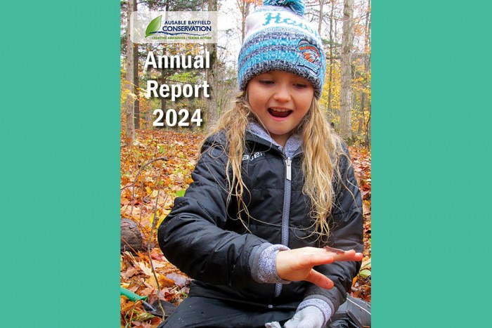 A photo of cover of Annual Report 2024 with photo of girl holding salmander.