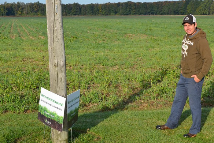 Brandon Coleman of Coleman Farms by cover crop sign.