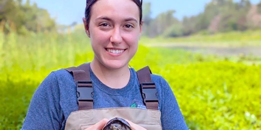 Mercedes Prout (with handling certificate) holds turtle that is re-released into the wild after healing.